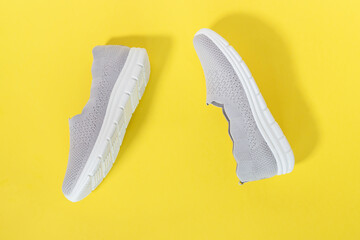 Summer rag gray sneakers for women, without heels on yellow a background. The concept of sales and advertising. flatly. From above. summer holidays.