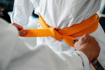 Mestre amarrando faixa taekwondo