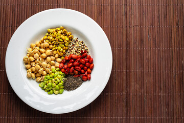 Vegan food. Sprouted grains in white dish on bamboo background