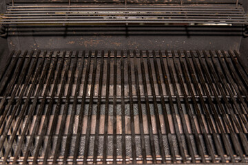 Fototapeta premium Old Empty Barbecue Grill Texture with a Thick Layer of Soot and Carbon. Dirty Iron Bbq Lattice Background Top View with Place for Text. Dark Key Photo Template for Product Advertising .