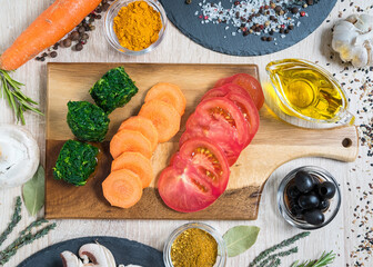 Food ingredients for cooking culinary dishes, vegetables cut on a wooden cutting board