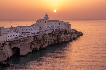 scenic view of sun rising above the church of San Francesco and the original town centre of Vieste,...