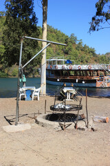 Fototapeta na wymiar Roaster for roasting lamb meat in foil for tourists on the shores of a picturesque bay.