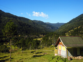 Casa no vale com fundo de montanhas