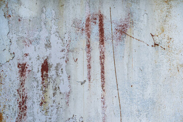 The surface of an old metal wall. There are several partially destroyed layers of paint of different colors and scratches. White, gray, brown. Background. Texture.