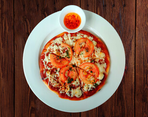 pizza with sauce and tomato, Nepali pizza served with sauce over a rustic wooden background.