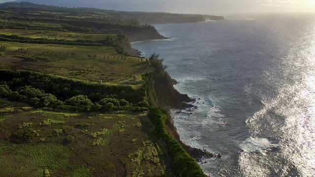 4K drone video of green coastline cliffs on a tropical island at sunset