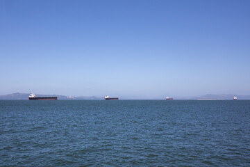 Barges on the horizon in Astoria, Oregon on a bright blue sunny sky day.