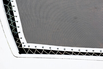Part of a stretched white net with ropes threaded into loops on the catamaran hull.