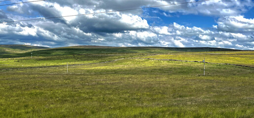 Fototapeta premium Extensive moorland landscape, with broken cloud and distant hills in, Holme Chapel, Burnley, UK