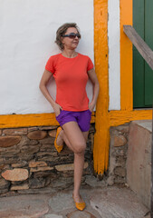 Lady leaning against a White Background with Yellow Trim and matching shoes