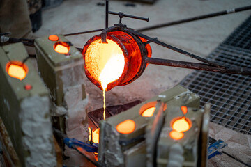 Container pouring melted bronze in workshop
