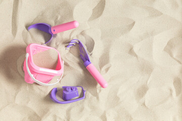 Bright plastic children's toys in sand. Concept of beach recreation for children. Top view.  Flat lay, top view, copy space