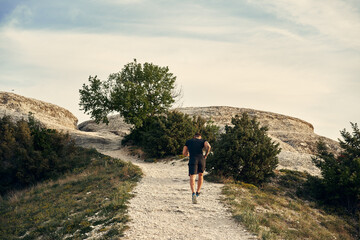 Fototapeta premium Young muscular male athlete running up the hill