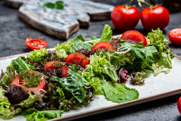 Salad with chicken liver. Fresh vegetable salad. Meat salad with liver, salad leaves, cheese, tomatoes on plate. Diet menu. Top view