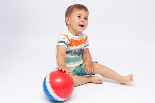 A cute image of a baby holding a ball. Image is isolated on white backround