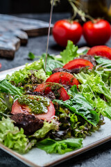 Hot salad with chicken liver, mushrooms, salad leaves, parmesan cheese and cherry tomatoes on plate. Dietary menu. vertical image. top view. place for text