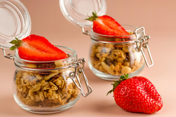 Muesli with fruits and strawberries on a pink background. Granola healthy food dessert snack. Keeping a healthy breakfast. Diet concept. Vegetarian food.