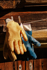 old gardening gloves are hanging on a rope by the barn
