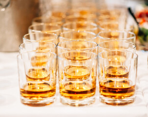 Glasses of whiskey on table