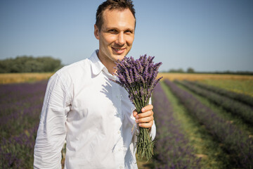 Farmer Holding a bouquet of lavender In Lavender Field On Sunset