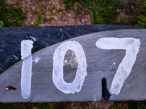 Top view of 107 written on a wooden fence in a field with a blurry backgroun