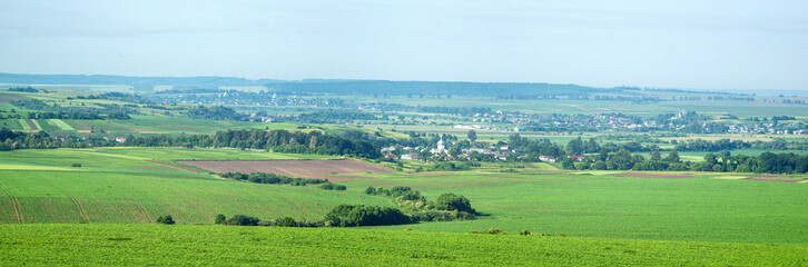 Fototapeta na wymiar Panorama of meadows, fields and the small town of Rohatyn on a sunny day in summer in Ukraine