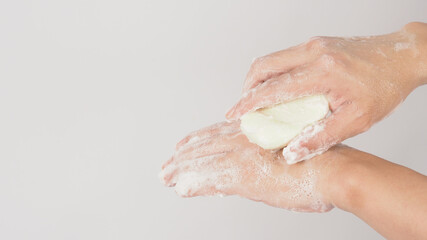 Fototapeta premium Hands washing gesture with bar soap and foam bubble on white background.