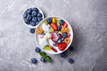 Bowl of healthy salad with fresh fruits, berries and yogurt