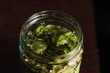 Homemade sunomono or cucumber pickles with sesame seeds inside a glass jar. Healthy, veggie and fresh.