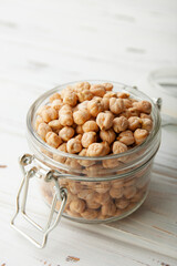 Raw chickpea beans in glass jar on wooden table. Uncooked chickpeas. Healthy eating