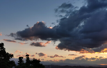 Fototapeta na wymiar Tramonto sulle montagne e le valli dell’Appennino con grandi nuvole colorate cariche di pioggia