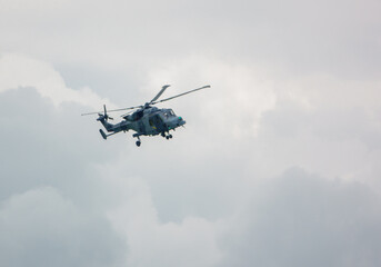 Fototapeta na wymiar British army AgustaWestland ZZ393 AW159 Wildcat AH1 helicopter flying in a cloudy sky, Wiltshire UK