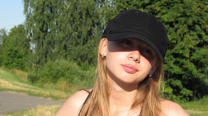 Portrait of a young girl in a cap in summer