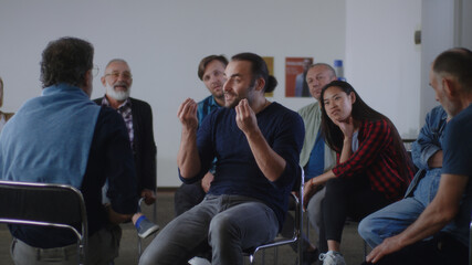 Optimistic reformed addict talking about life without alcohol during AA meeting