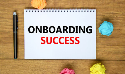 Fototapeta premium Onboarding success symbol. Words 'Onboarding success' on white note on beautiful wooden table, colored paper, black metallic pen. Business, onboarding success concept. Copy space.