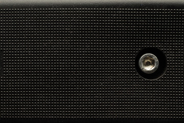 Black textured plastic surface with bumps and also hexagonal socket bolt head