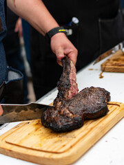 cowboy asado.

manos cortando cowboy asado.

cowboy asado sobre tabla de madera.

corte de res.