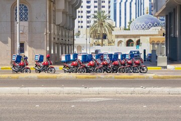  Food delivery service in UAE. Group of motorcycles parked on special parking on the street waiting...