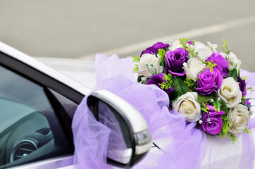 Purple and white flowers in the bouquet decorate the wedding car close-up with copy space. High quality photo