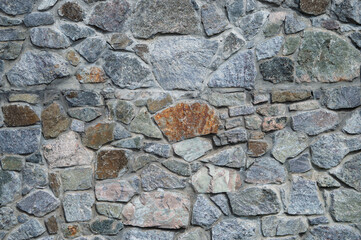 Ancient stone wall. Ruin. Gray stone background. Wall with peeling plaster.
