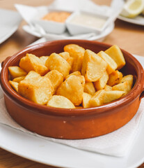 Plate of Spanish style patatas bravas with spicy sauce
