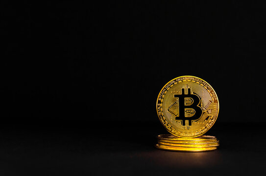Bitcoin BTC crypto currency gold coins on black background, new virtual money concept. Mining or blockchain technology