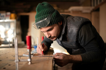 Focused craftsman making marks on board