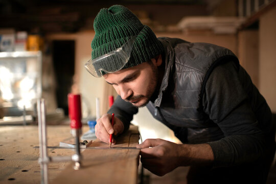 Focused craftsman making marks on board