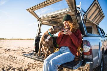 Young woman enjoying cup of coffee in the morning beach car camping