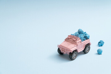 Cute pale pink toy truck delivering popcorns on a pastel blue background minimal with copyspace
