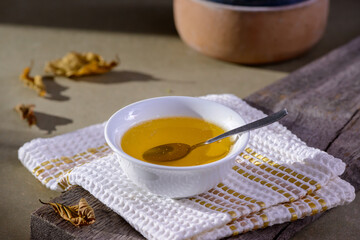 Ghee butter from India in white dinnerware container on wooden table.