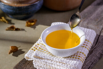 Ghee butter from India in white dinnerware container on wooden table.