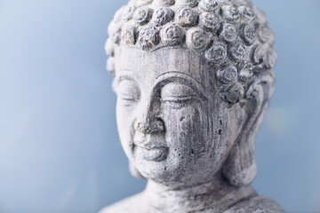 Fototapeta na wymiar Meditating Buddha Statue on bright background. Copy space. 